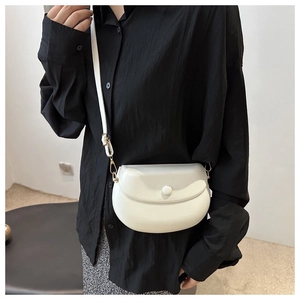 Detailed shot of white half-moon saddle bag with adjustable strap and metal buckle