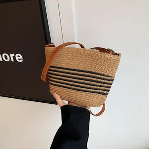 Striped straw bucket bag with brown leather shoulder strap for beach vacation