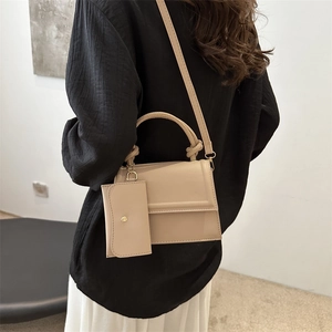 Minimalist beige leather crossbody square bag with knot handle and small decorative pouch
