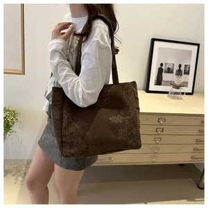Detail of dark brown corduroy tote bag with traditional Chinese floral embroidery