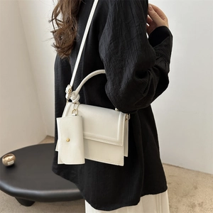 Minimalist white leather crossbody bag with top handle and detachable mini pouch