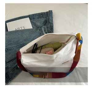 Spacious white canvas crossbody bag interior showing storage for daily essentials
