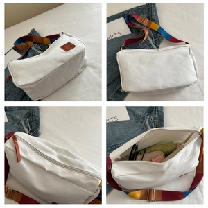 Detail of white canvas crossbody bag featuring colorful rainbow strap and interior capacity