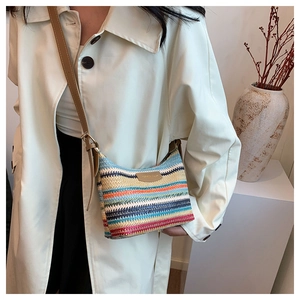 Close-up of rainbow striped straw bag with leather logo tag and fine strap detail