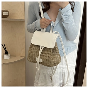 Detailed close-up of woven straw texture and white leather flap on casual backpack