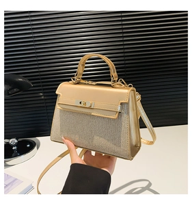 Detalle de bolso dorado con purpurina brillante y cierre giratorio de metal elegante