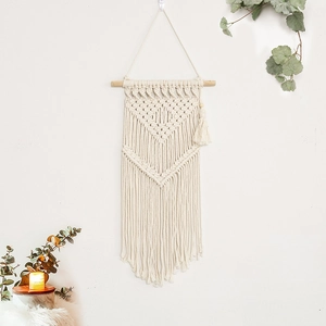 Handwoven bohemian wall hanging with geometric patterns and cotton tassels on wood