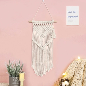 Bohemian cream white woven cotton tapestry with long tassels on a natural wood rod