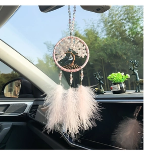Macro detail of pink crystal tree of life car charm with soft feathers and beads
