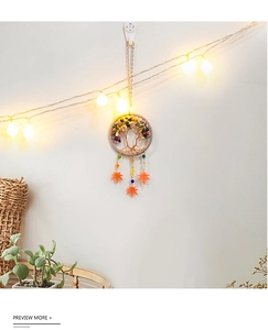 Detail of tree of life dreamcatcher with colorful crystals and orange maple leaf charms