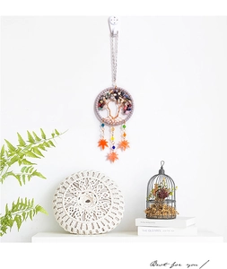 Detail of tree of life car charm with colorful gemstones and orange maple leaf pendants