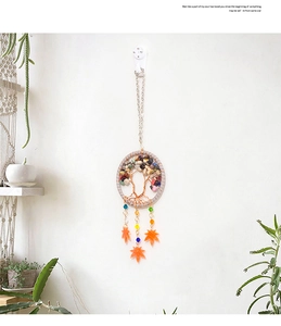 Detail of tree of life dreamcatcher car hanging with colorful stones and orange leaves