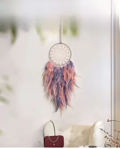 Detail of bohemian dream catcher with pink and purple feathers and pearl beads decor