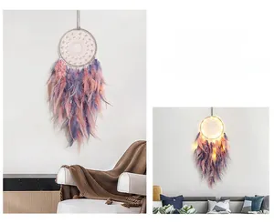 Detail of handmade dream catcher with gradient feathers, pearls, and warm LED light effect