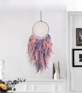 Detail view of handmade dream catcher featuring purple feathers and white beaded webbing