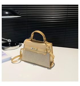 Detalle de elegante bolso dorado champán con textura tejida y cierre giratorio de metal