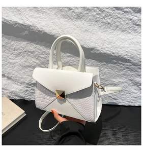 Vue détaillée du sac carré blanc avec boucle dorée et accents de texture crocodile élégants