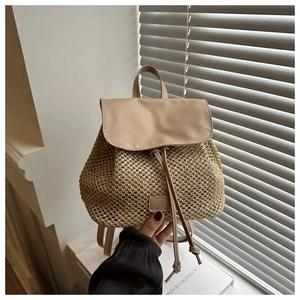 Detail of straw backpack with leather flap, drawstring closure and woven texture