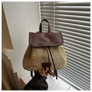 Detail of bohemian straw backpack featuring woven texture and brown leather straps