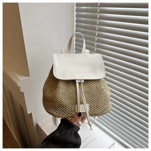 Close-up of the woven straw texture and white leather flap on this stylish summer backpack