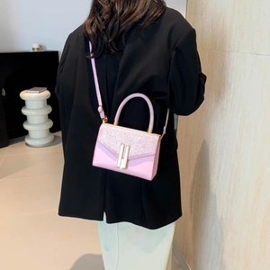 Pink minimalist crossbody bag with glitter flap and gold accents worn by model