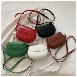 Detailed view of five colorful leather saddle bags in red, black, brown, green and white