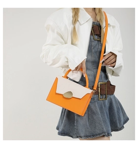 Chic orange and beige crossbody bag with pebble metal buckle shown on a female model