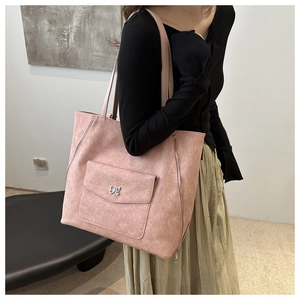 Détail du grand sac cabas rose avec boucle en métal papillon sur la poche frontale