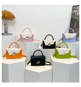 Collection of minimalist leather handbags with gold metal clasps on geometric stands