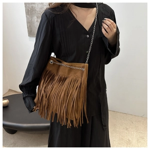 Détail du sac bandoulière vintage en daim marron avec franges et bandoulière en chaîne