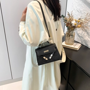 Bolso chic de lentejuelas negras con cierre dorado llevado como bandolera mujer