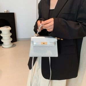 Elegante mini bolso trapecio azul claro con cierre giratorio de metal y asa de cuero