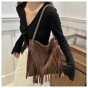 Détail d'un sac cabas marron à franges en daim avec élégantes chaînes métalliques