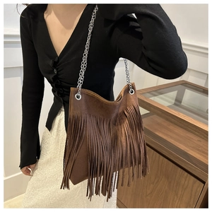 Détail d'un sac cabas en daim marron avec franges bohèmes et bandoulière chaîne argent