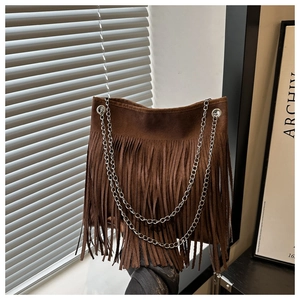 Gros plan du sac en daim marron foncé avec de longues franges et une chaîne en argent