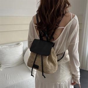 Women's woven straw backpack with black leather straps for summer beach travel