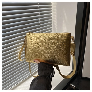Detail of golden crocodile embossed leather bag texture with metal zipper and strap