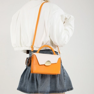 Fashionable orange and beige patchwork crossbody handbag with elegant gold buckle