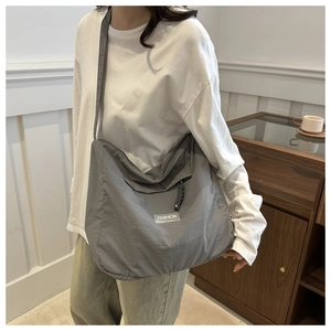 Gray large capacity nylon tote bag with fashion label shown in a lifestyle setting