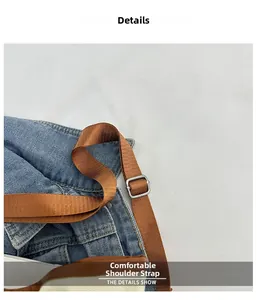 Detail of adjustable brown nylon shoulder strap with silver buckle on denim bucket bag