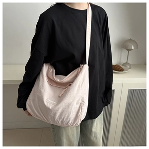 Detail of light pink large nylon tote bag with fashion patch and woven zipper cord