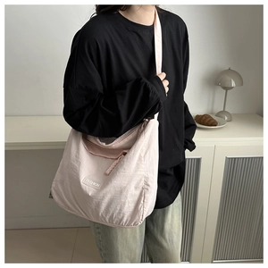 Detail of light pink large capacity tote bag with Fashion label and wide strap