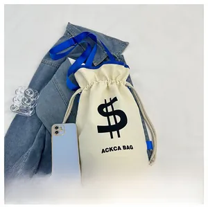 Size comparison of white canvas bucket bag with blue strap beside a smartphone