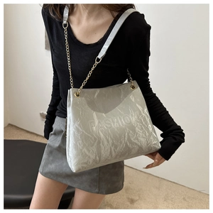 Detail of silver metallic crinkled leather tote with golden chain and Fashion logo