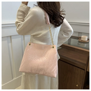 Détail du grand sac rose avec texture plissée, chaîne dorée et inscription FASHION en relief