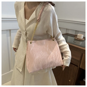 Pink pleated tote bag with FASHION lettering and gold chain strap on female model