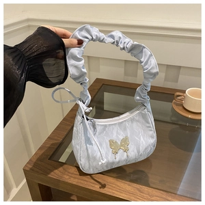 Close-up of light blue crescent bag with silver butterfly buckle and scrunchie handle