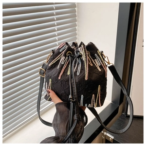 Macro view of black nylon bucket bag featuring colorful wavy embroidery and drawstring