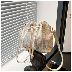 Macro shot of white bucket bag with rainbow embroidery and F-pattern embossed texture