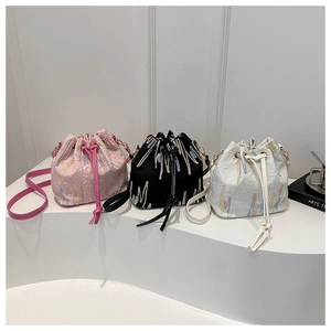 Three colors of embroidered monogram canvas drawstring bucket bags with slim straps